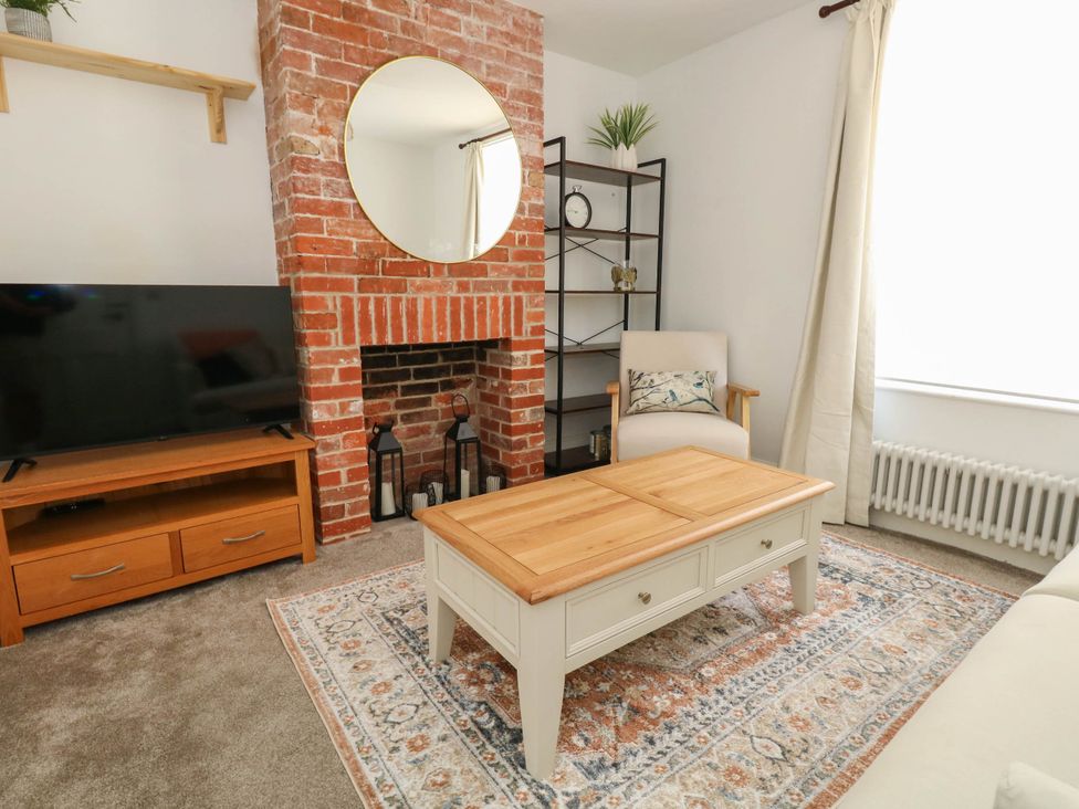 A living room with a coffee table and a television at The Watch House in Weymouth