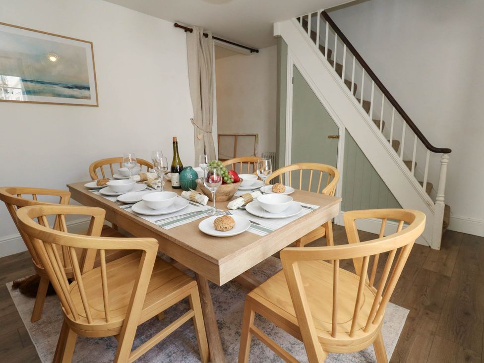 A dining room with a table set for meals at The Watch House in Weymouth