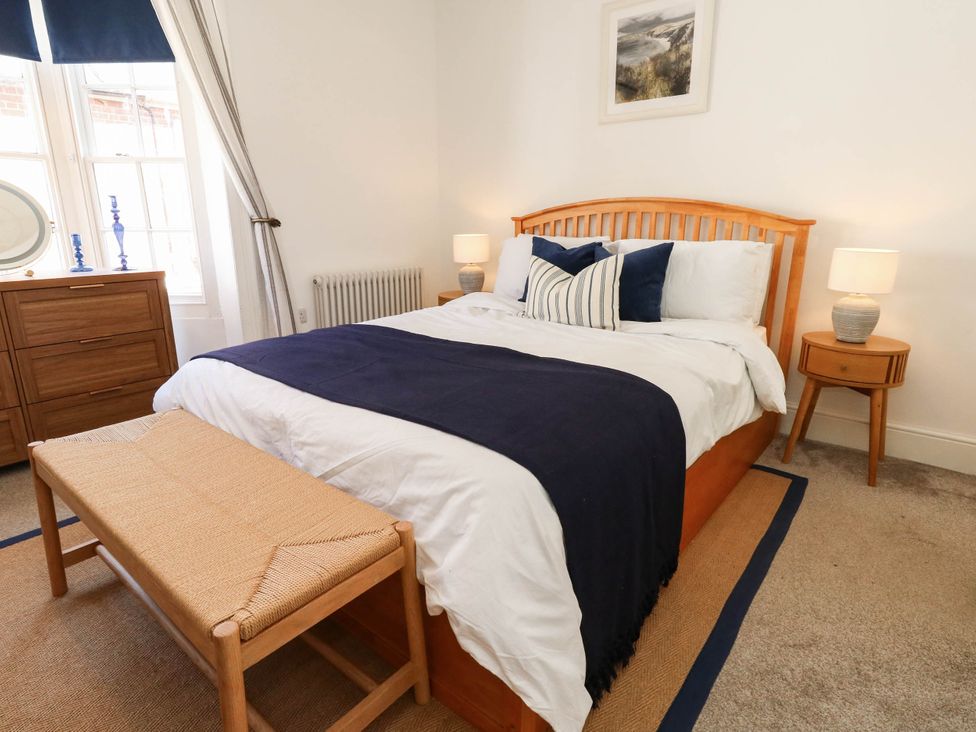 A bedroom with a wooden bed and bedside tables at The Watch House in Weymouth