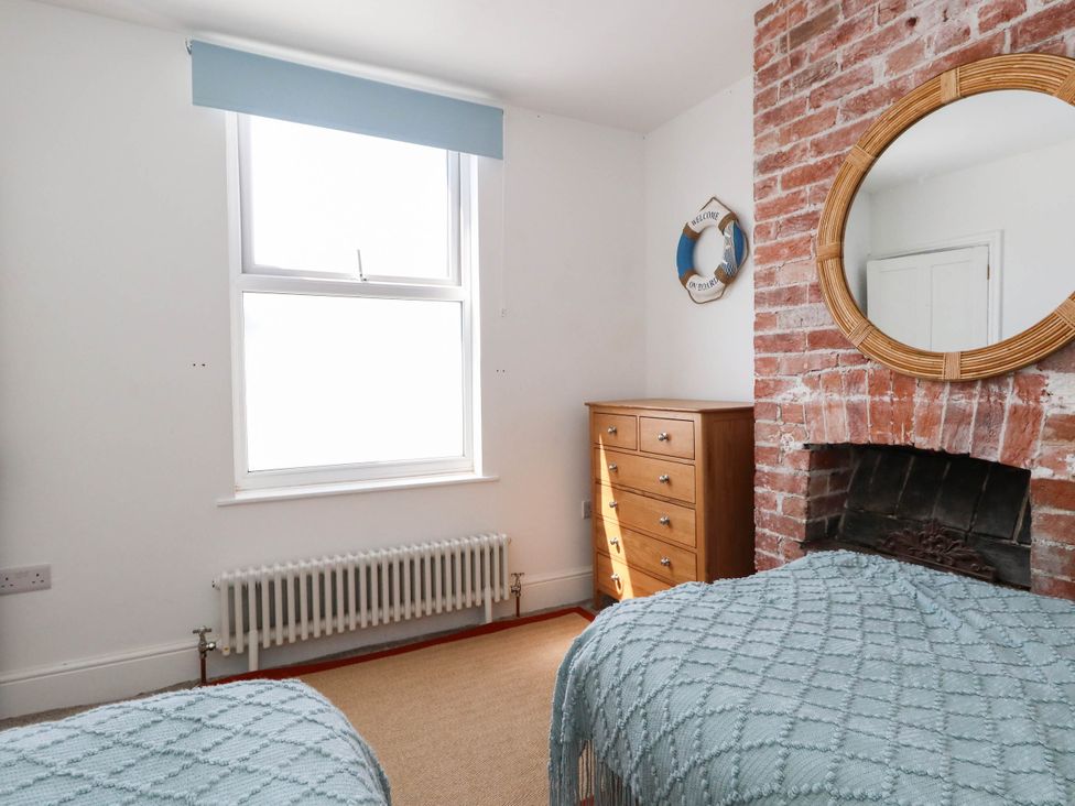 A bedroom with a window and a dresser at The Watch House in Weymouth