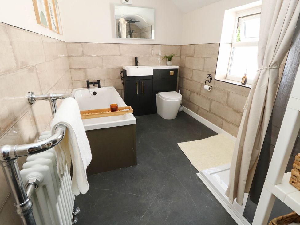 A bathroom with a bathtub, toilet, and sink at The Watch House in Weymouth