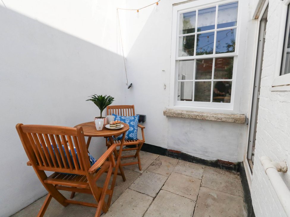 An outdoor area with a table and chairs at The Watch House in Weymouth