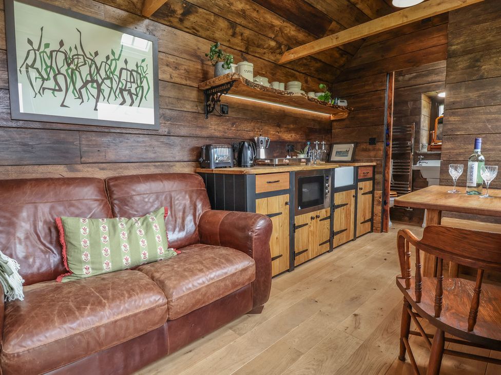 A living room with a sofa and kitchen counter at Cloud Cabin