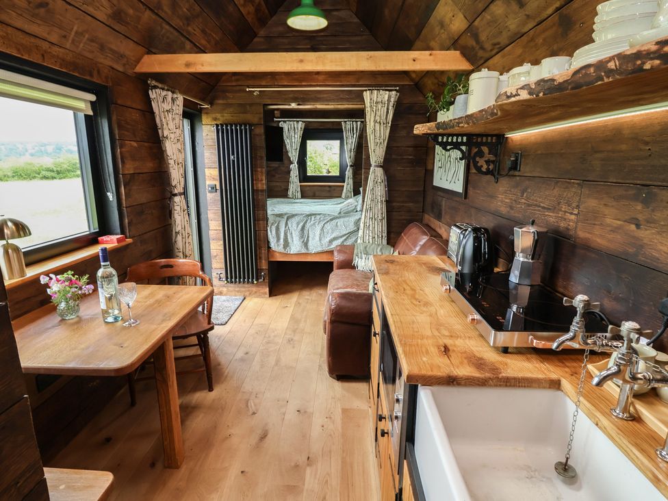 A kitchen with a seating area and a bed at Cloud Cabin