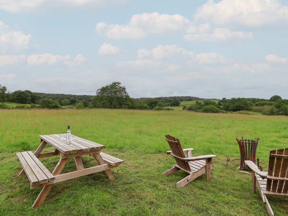 An outdoor area with a picnic table and wooden chairs at Cloud Cabin