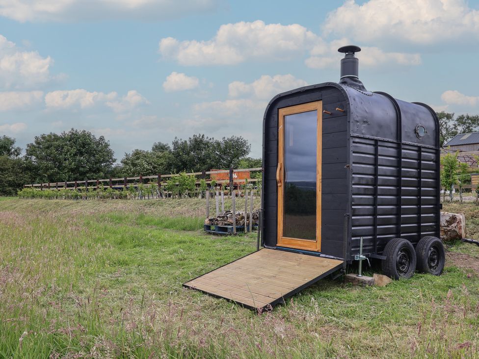 A black shed with wooden door and chimney at Cloud Cabin