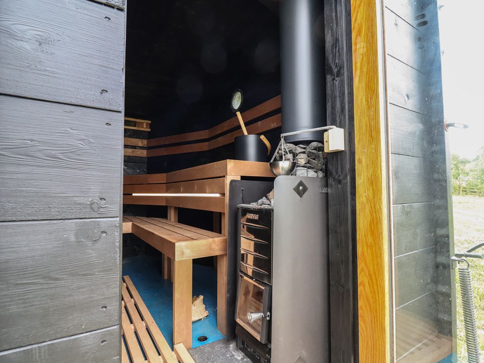 A sauna with wooden benches and a stove at Cloud Cabin
