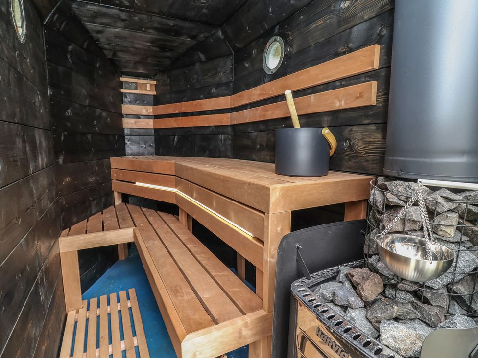 A sauna with wooden benches and heating stove at Cloud Cabin