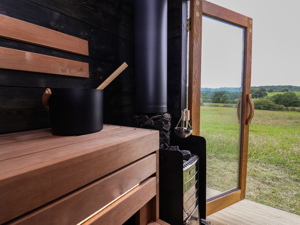 A sauna with a wooden bench and stove at Cloud Cabin