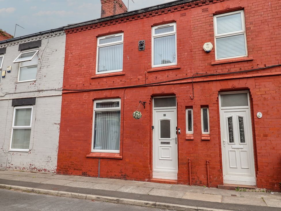 A red house adjacent to a white house on Lunt Road in Bootle