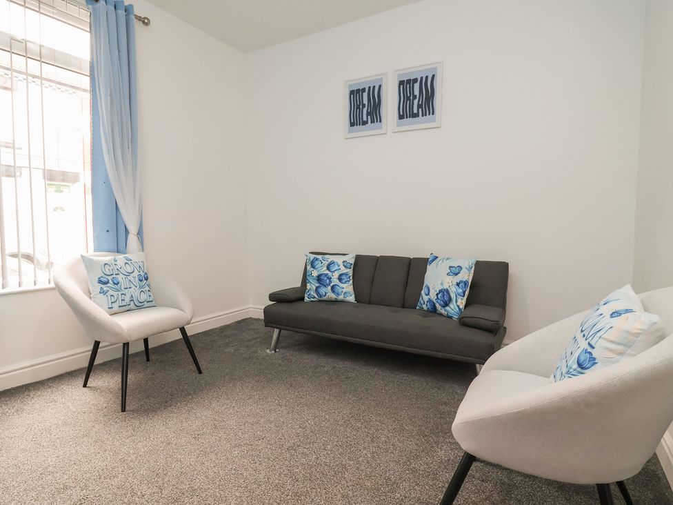 A living room with a sofa and chairs at Lunt Road in Bootle