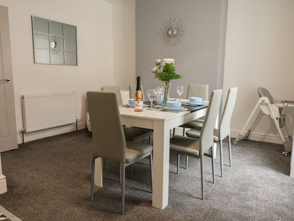 A dining room with a table set for meals at Lunt Road in Bootle
