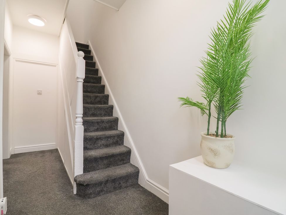 A hallway with a staircase and a plant at Lunt Road in Bootle