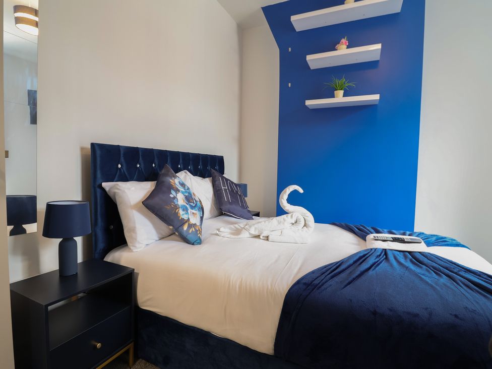 A bedroom with a bed and bedside table at Lunt Road in Bootle