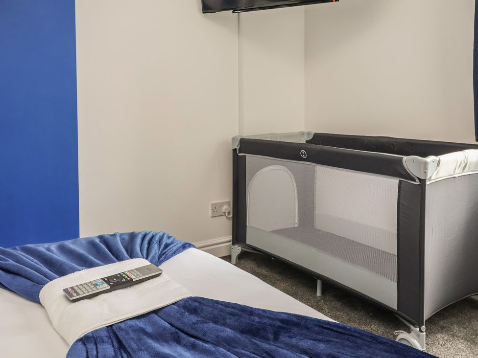 A bedroom with a bed and a crib at Lunt Road in Bootle