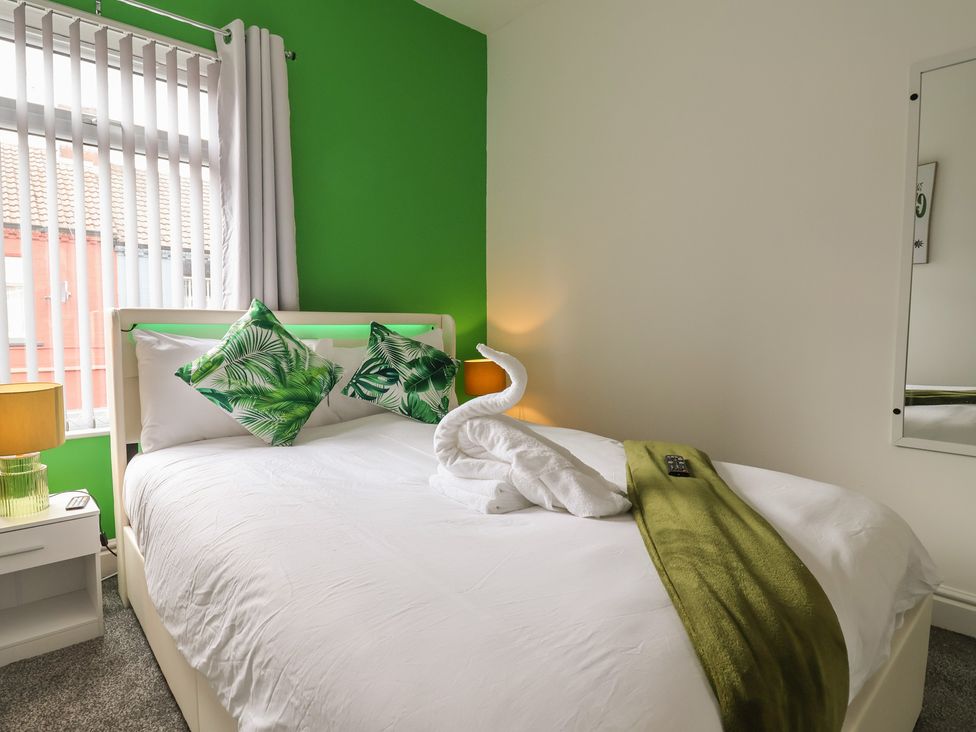A bedroom with a bed and decorative pillows at Lunt Road in Bootle