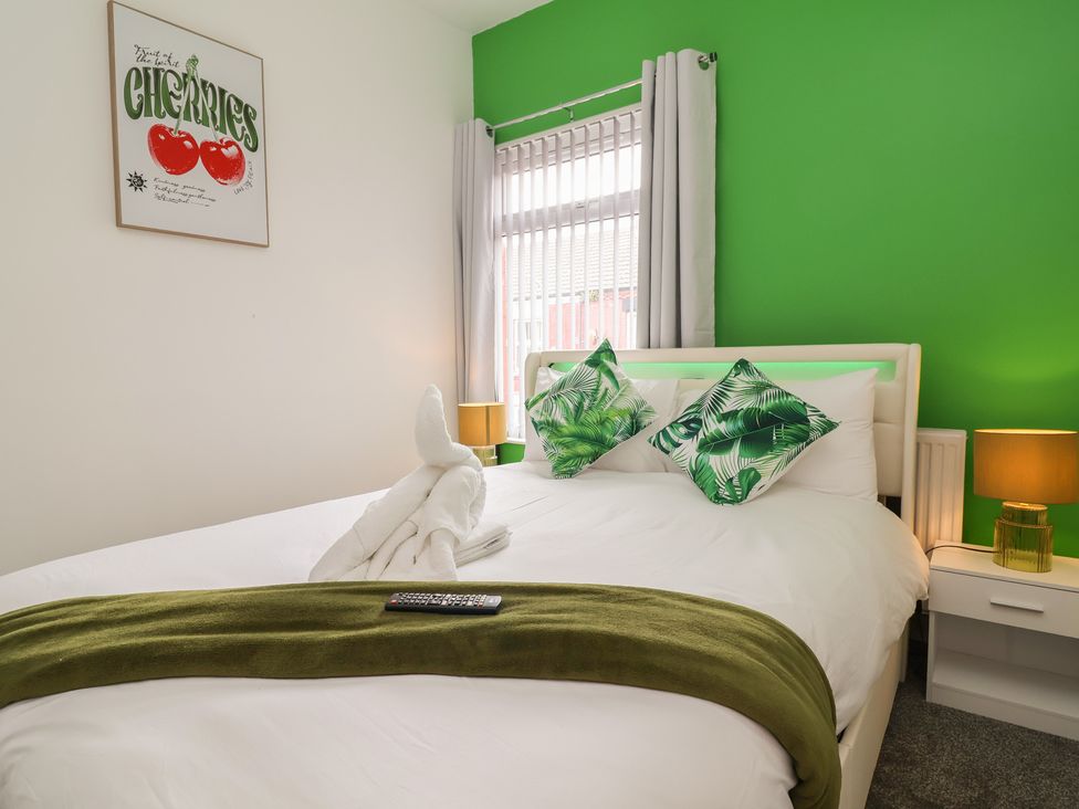 A bedroom with a bed and decorative pillows at Lunt Road in Bootle