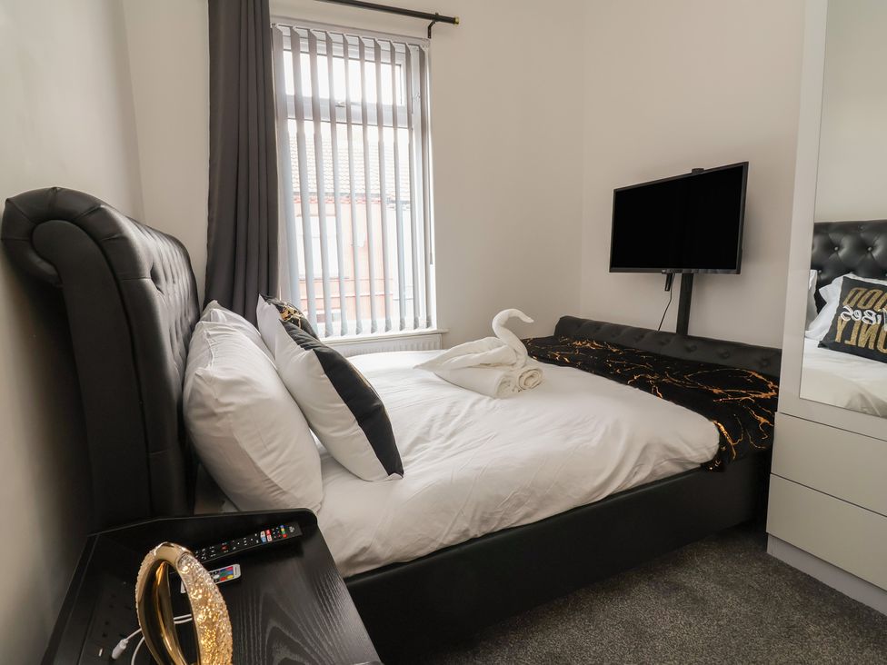 A bedroom with a bed and television at Lunt Road in Bootle