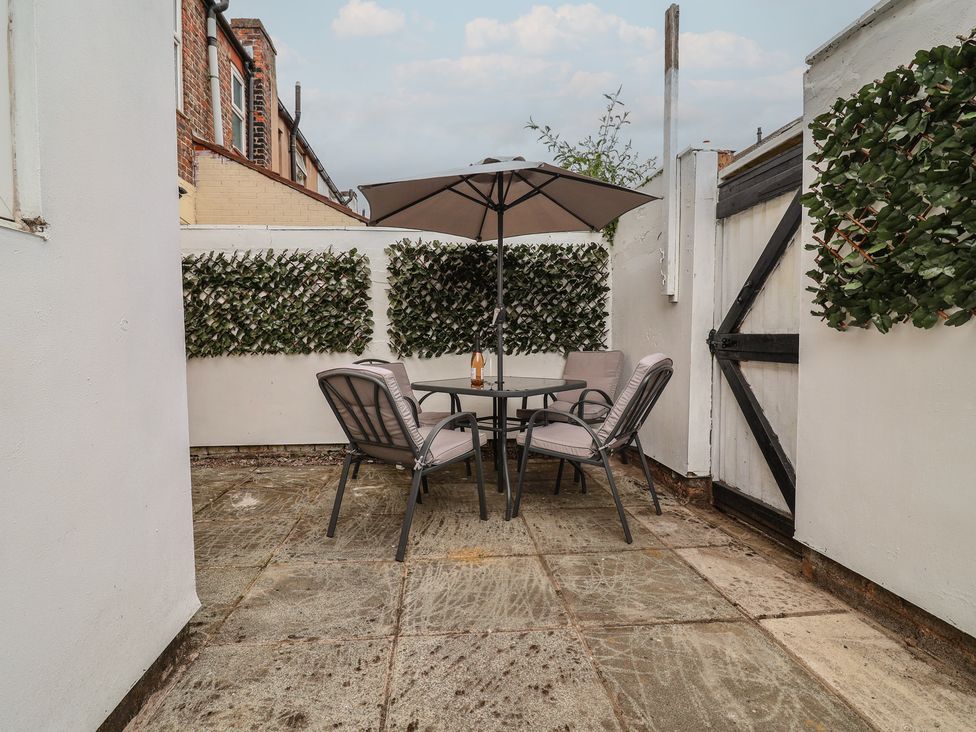 A garden with a table and chairs under an umbrella at Lunt Road in Bootle