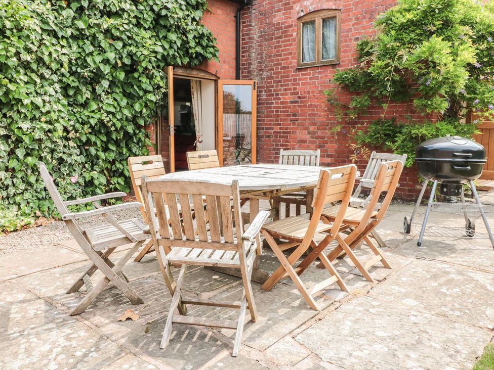An outdoor dining area with a table and chairs at The Hop Kiln in Tenbury Wells