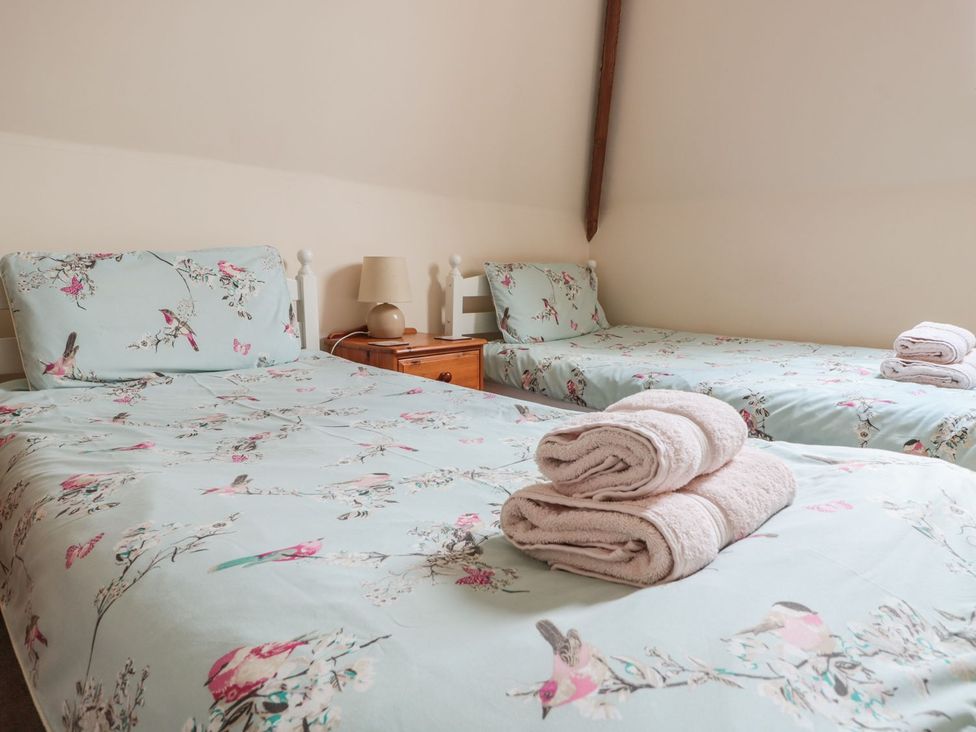 A bedroom with two beds and a nightstand at The Hop Kiln in Tenbury Wells