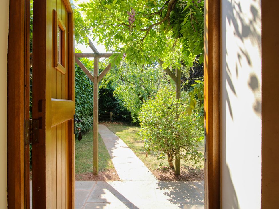 A garden with a path and green plants at The Hop Kiln in Tenbury Wells