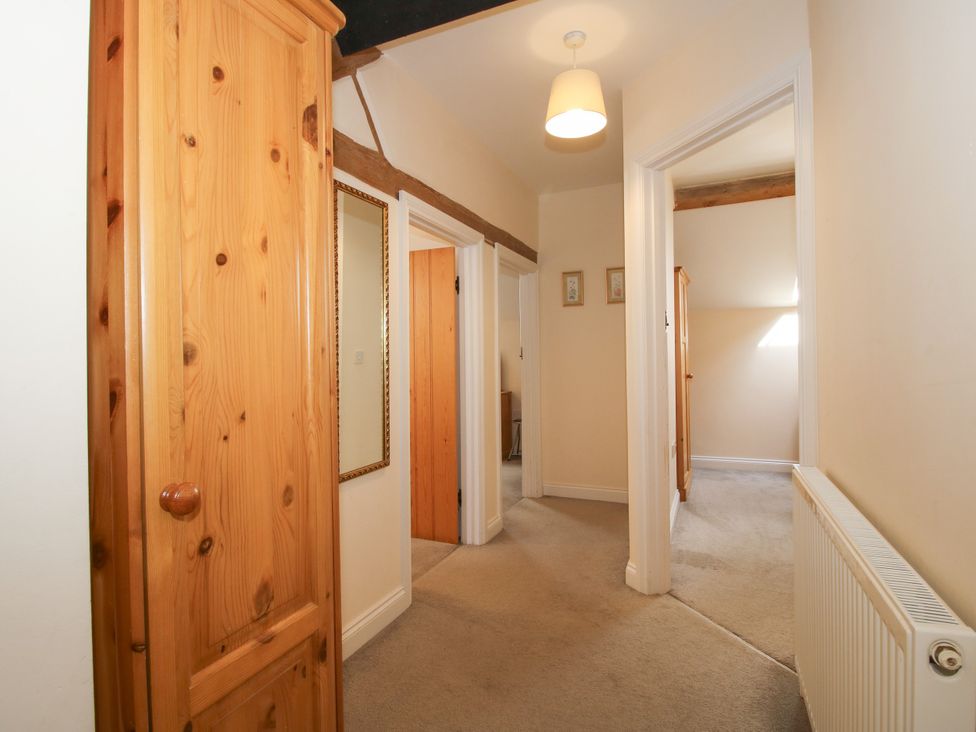 A hallway with wooden wardrobe and mirror at The Hop Kiln in Tenbury Wells