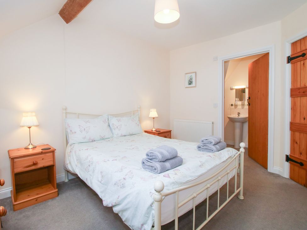 A bedroom with a bed and nightstand at The Hop Kiln in Tenbury Wells