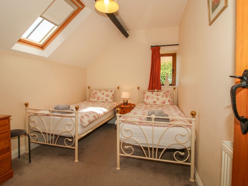 A bedroom with two single beds and a window at The Hop Kiln in Tenbury Wells
