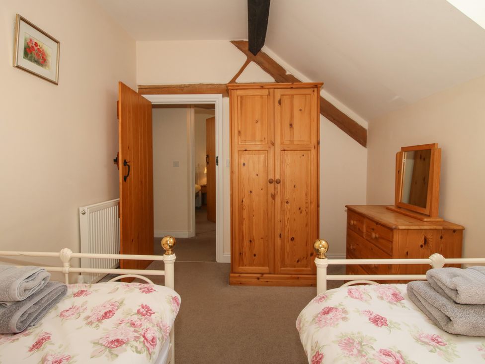A bedroom with two beds and a wardrobe at The Hop Kiln in Tenbury Wells
