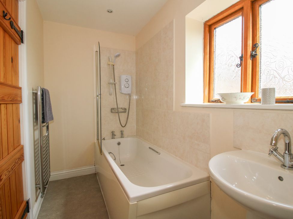 A bathroom with a bath and sink at The Hop Kiln in Tenbury Wells