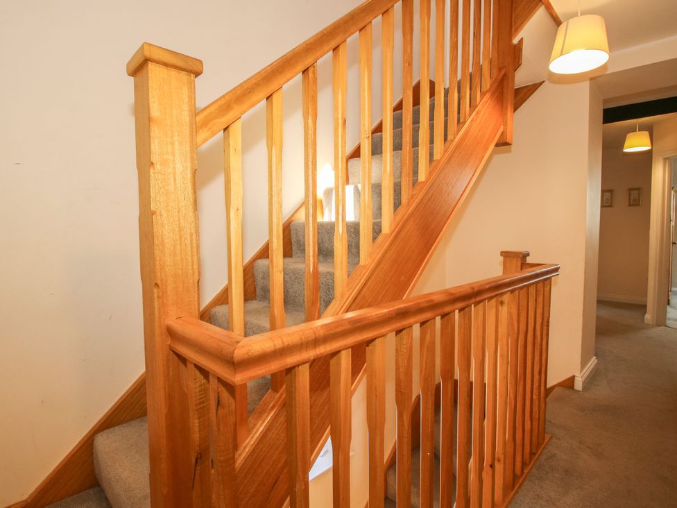 A staircase with wooden handrail and carpet in the hallway at The Hop Kiln in Tenbury Wells