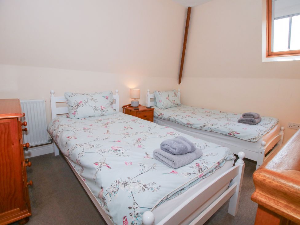 A bedroom with two single beds and a dresser at The Hop Kiln in Tenbury Wells