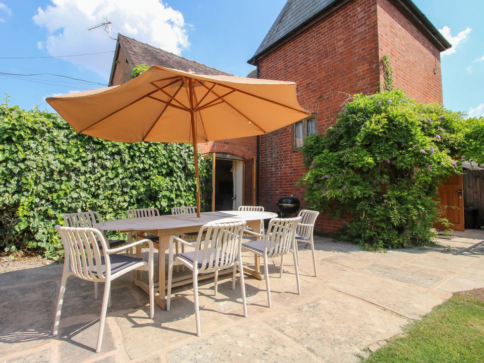 An outdoor dining area with a table and chairs at The Hop Kiln in Tenbury Wells