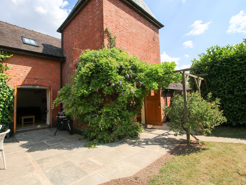 A garden area with a brick wall and door at The Hop Kiln in Tenbury Wells