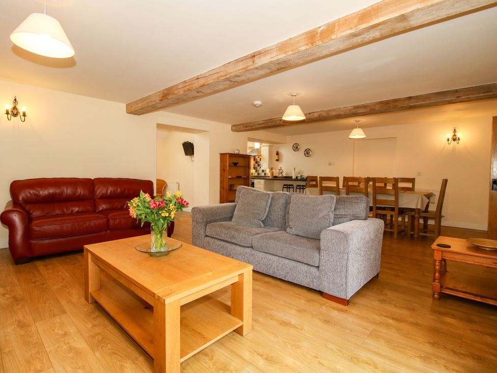 A living room with a red sofa and a coffee table at The Hop Kiln in Tenbury Wells