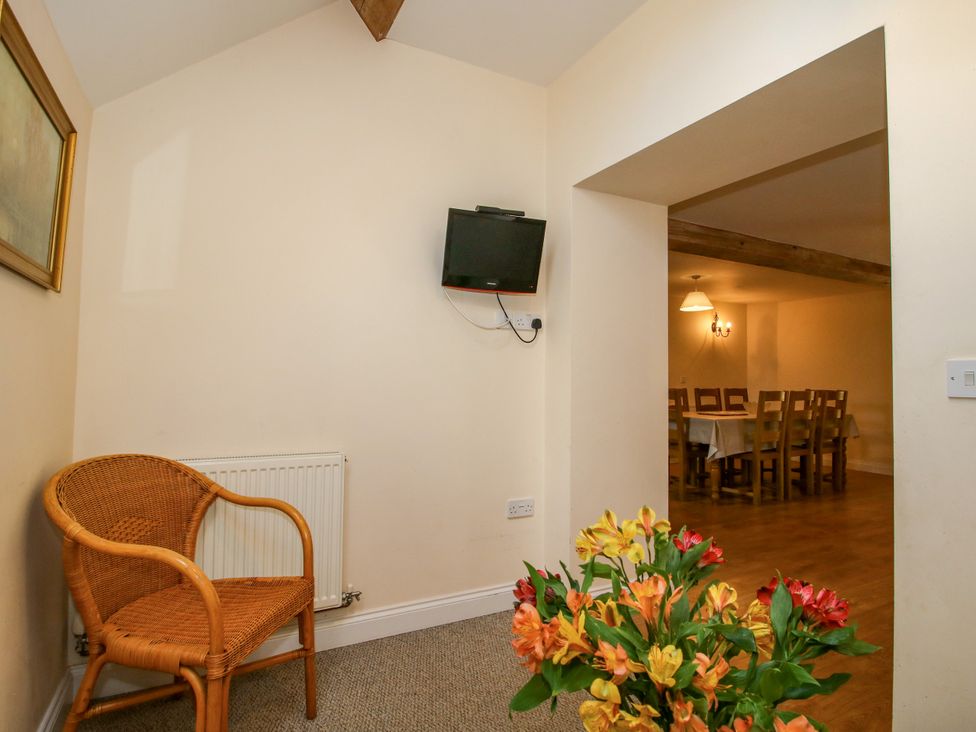 A dining room with a wicker chair and table at The Hop Kiln in Tenbury Wells