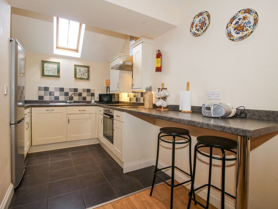 A kitchen with appliances and a bar seating area at The Hop Kiln in Tenbury Wells