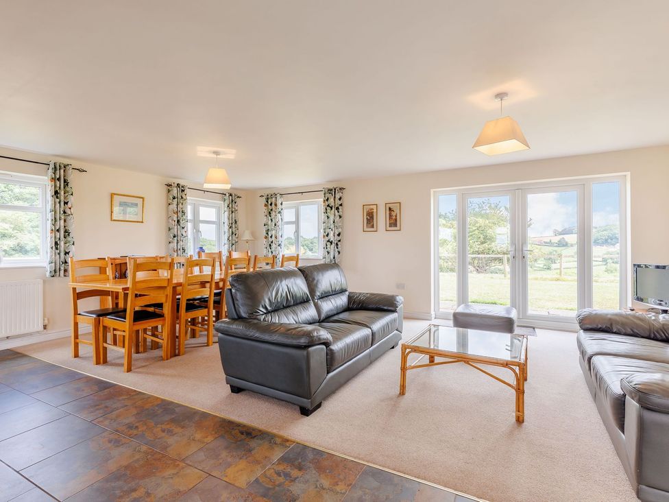 A living room with a sofa and dining table at Wood Cottage in Tenbury Wells