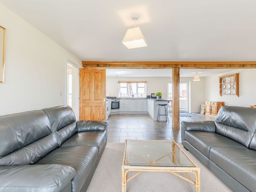 A living room with sofas and a table at Wood Cottage in Tenbury Wells