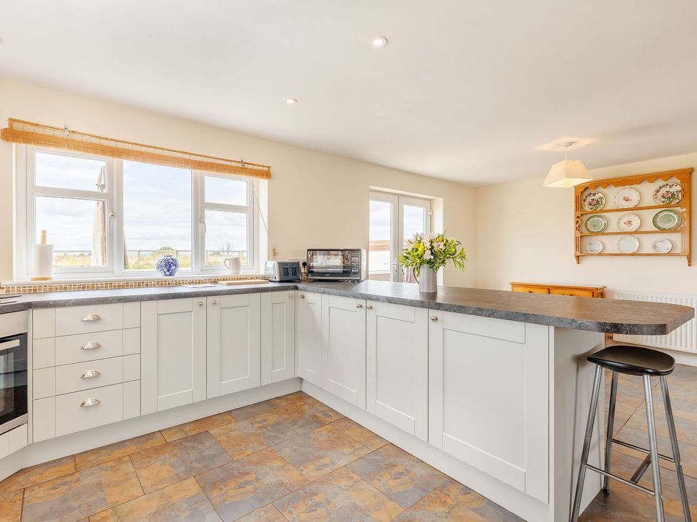 A kitchen with a countertop and windows at Wood Cottage in Tenbury Wells