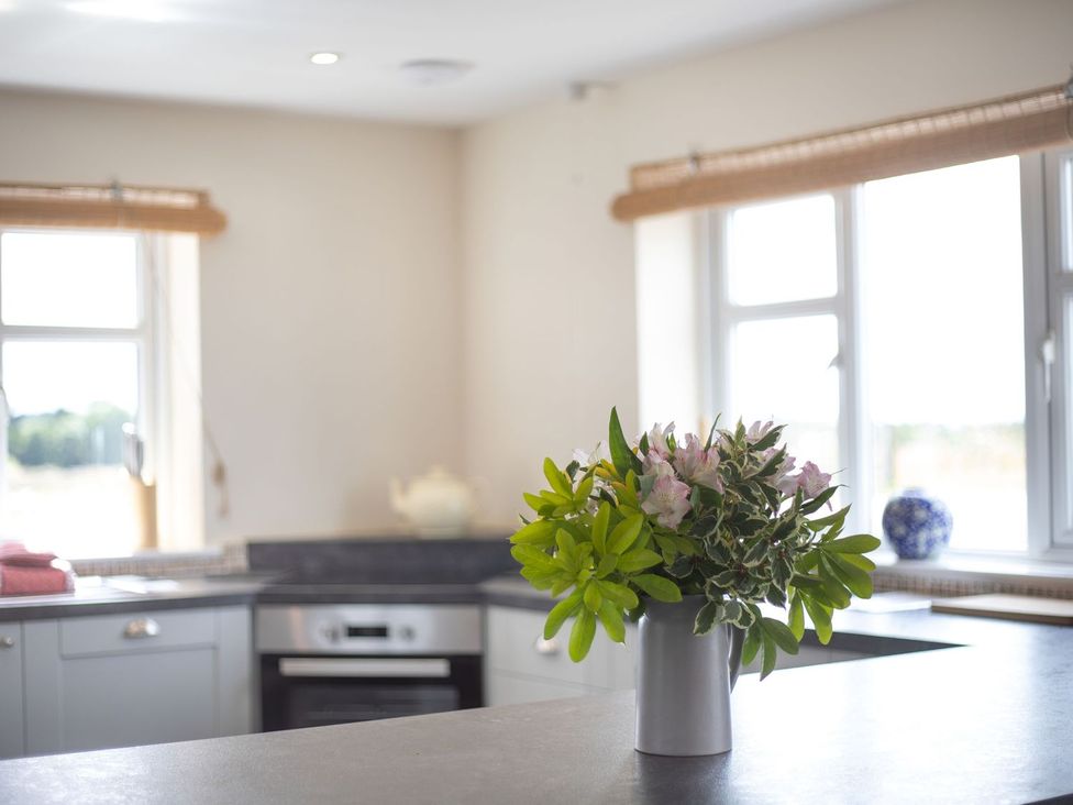 A kitchen with flowers on the countertop at Wood Cottage Tenbury Wells