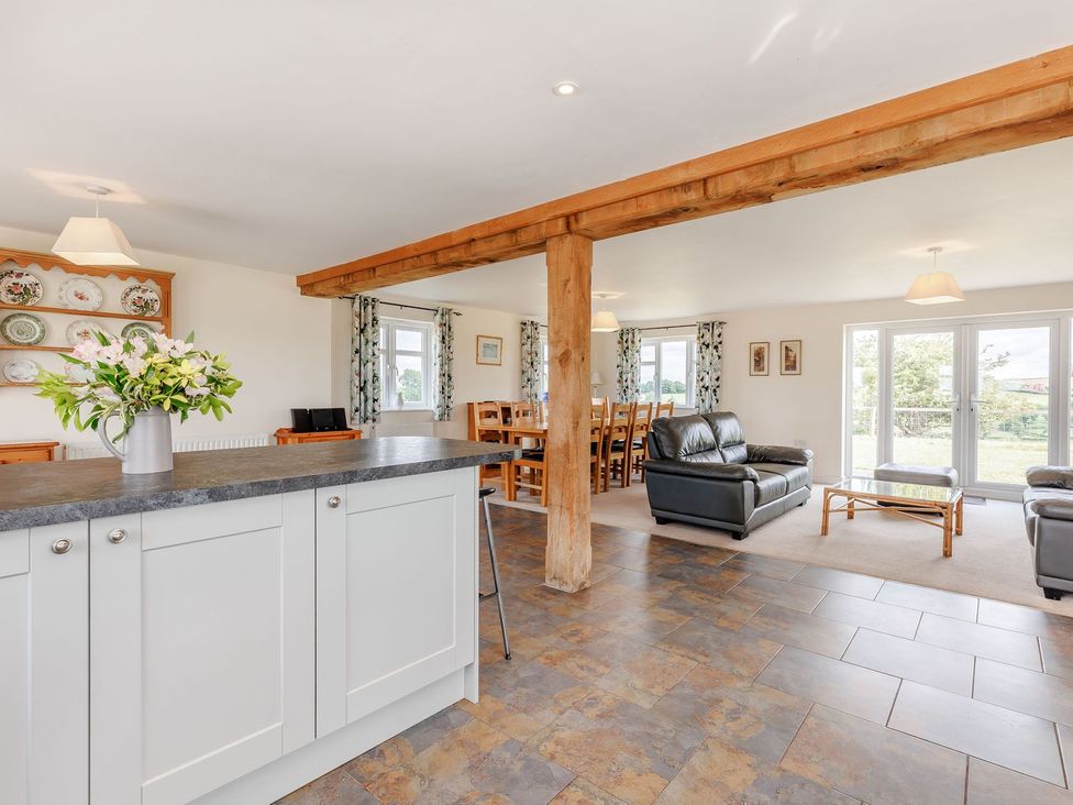 A living room with a sofa and dining area at Wood Cottage in Tenbury Wells