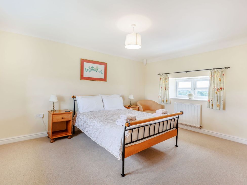 A bedroom with a bed and nightstand at Wood Cottage in Tenbury Wells