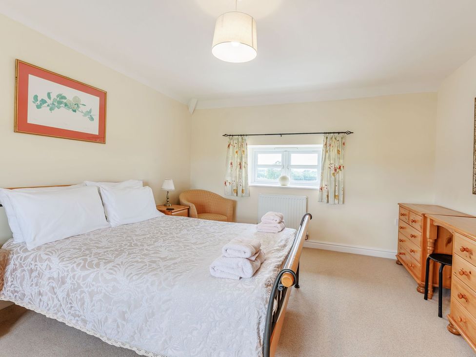 A bedroom with a bed and a desk at Wood Cottage in Tenbury Wells