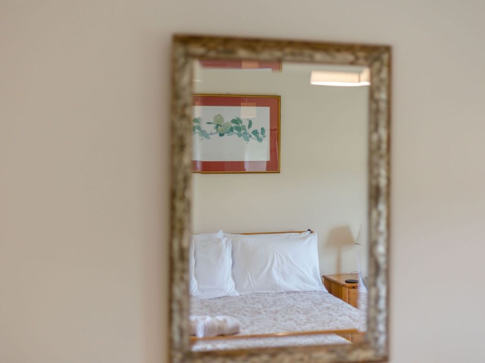 A bedroom with a bed and bedside table at Wood Cottage Tenbury Wells