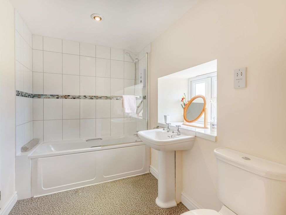 A bathroom with a bathtub, sink, and toilet at Wood Cottage in Tenbury Wells