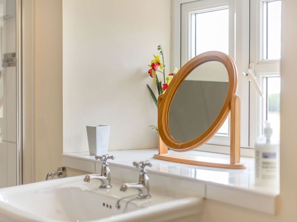 A bathroom with a sink and a mirror at Wood Cottage in Tenbury Wells