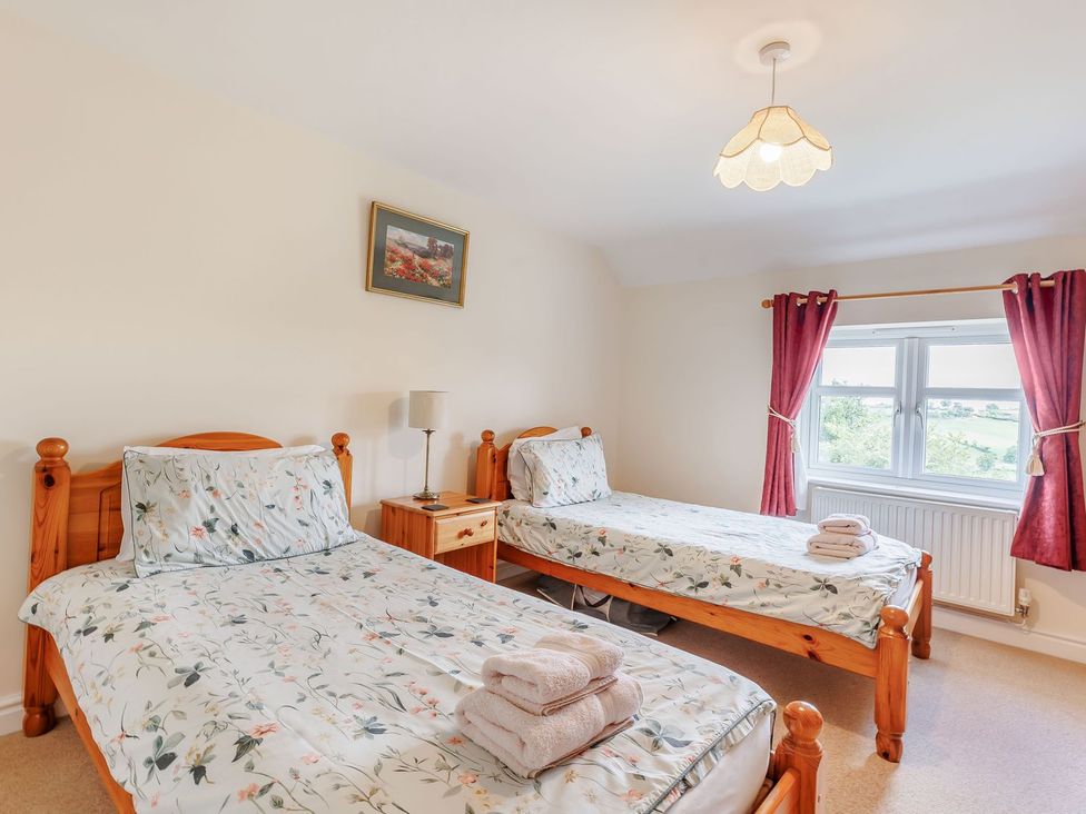 A bedroom with two single beds and a window at Wood Cottage in Tenbury Wells