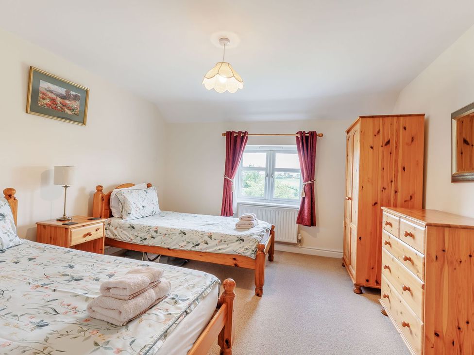 A bedroom with two beds and wooden furniture at Wood Cottage in Tenbury Wells